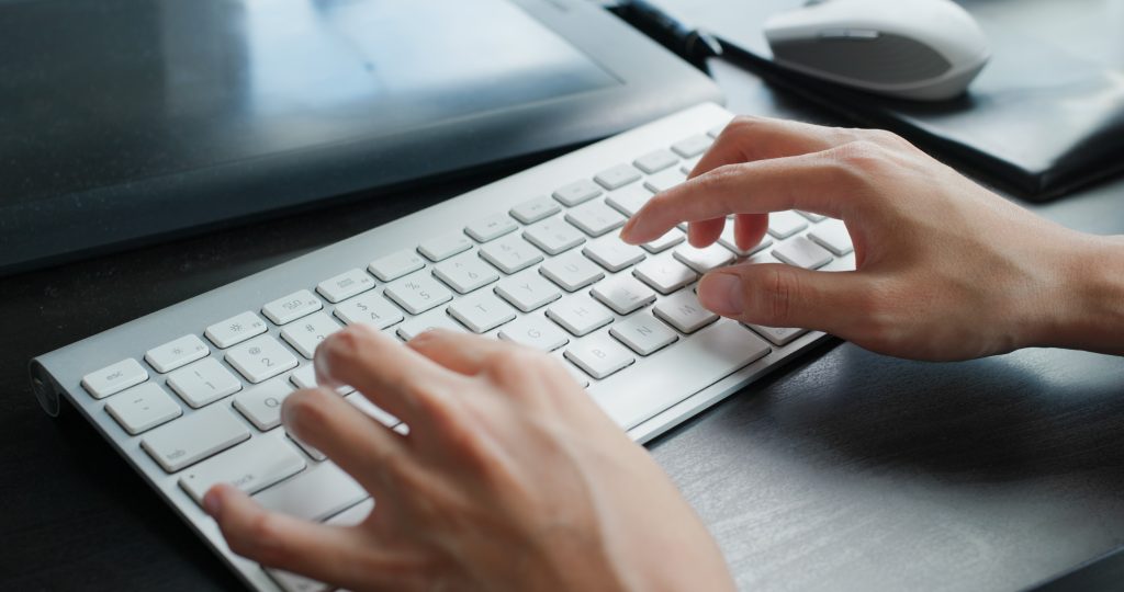 Frau tippt zu Hause auf der Tastatur